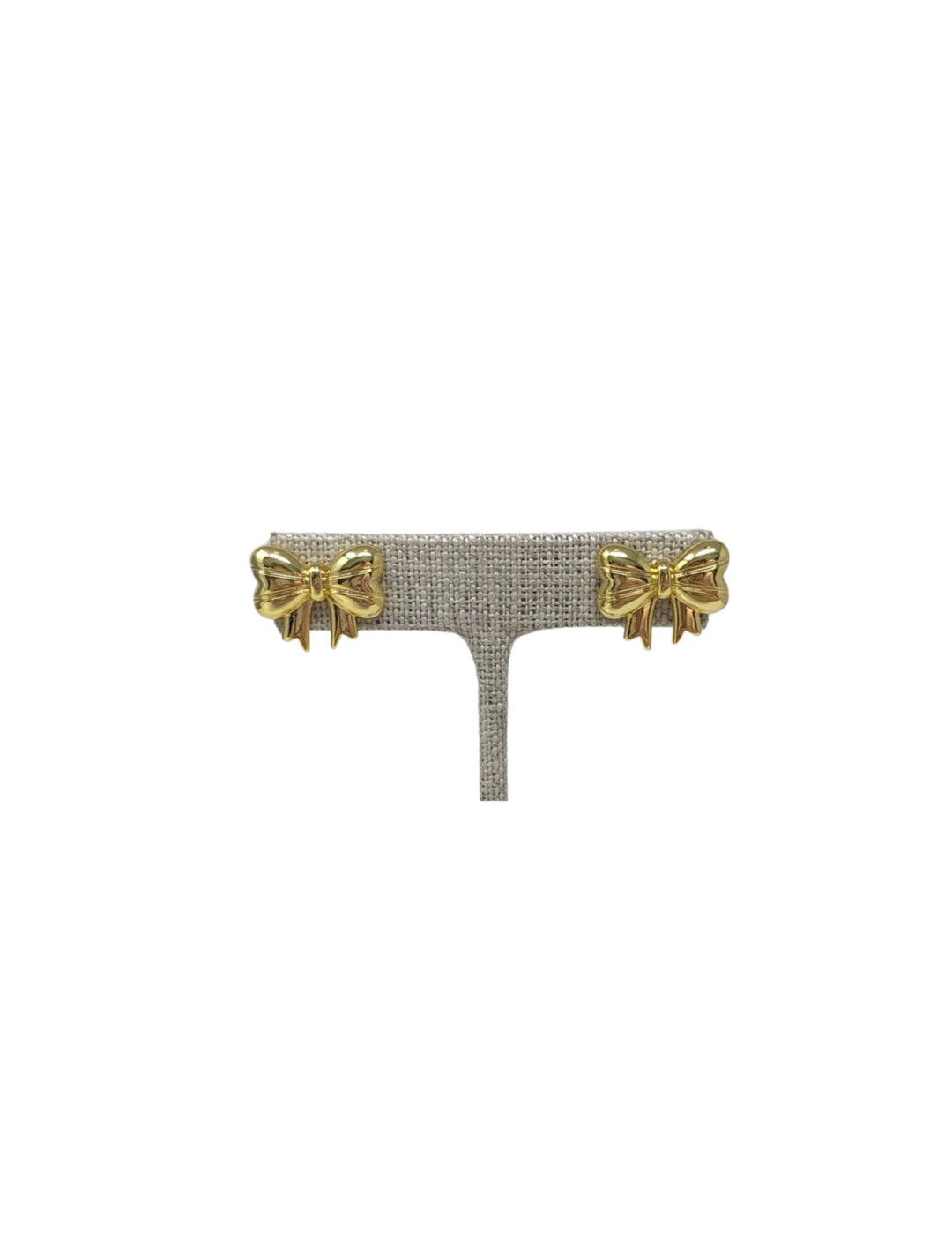 Pair of gold polished classic bow-shaped stud earrings displayed on a grey textured stand.