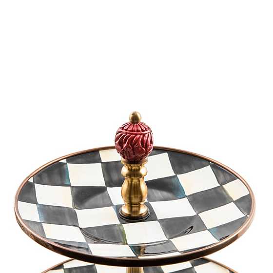 Close-up of a Courtly Check enamel stand featuring a hand-painted black and white checkered pattern.