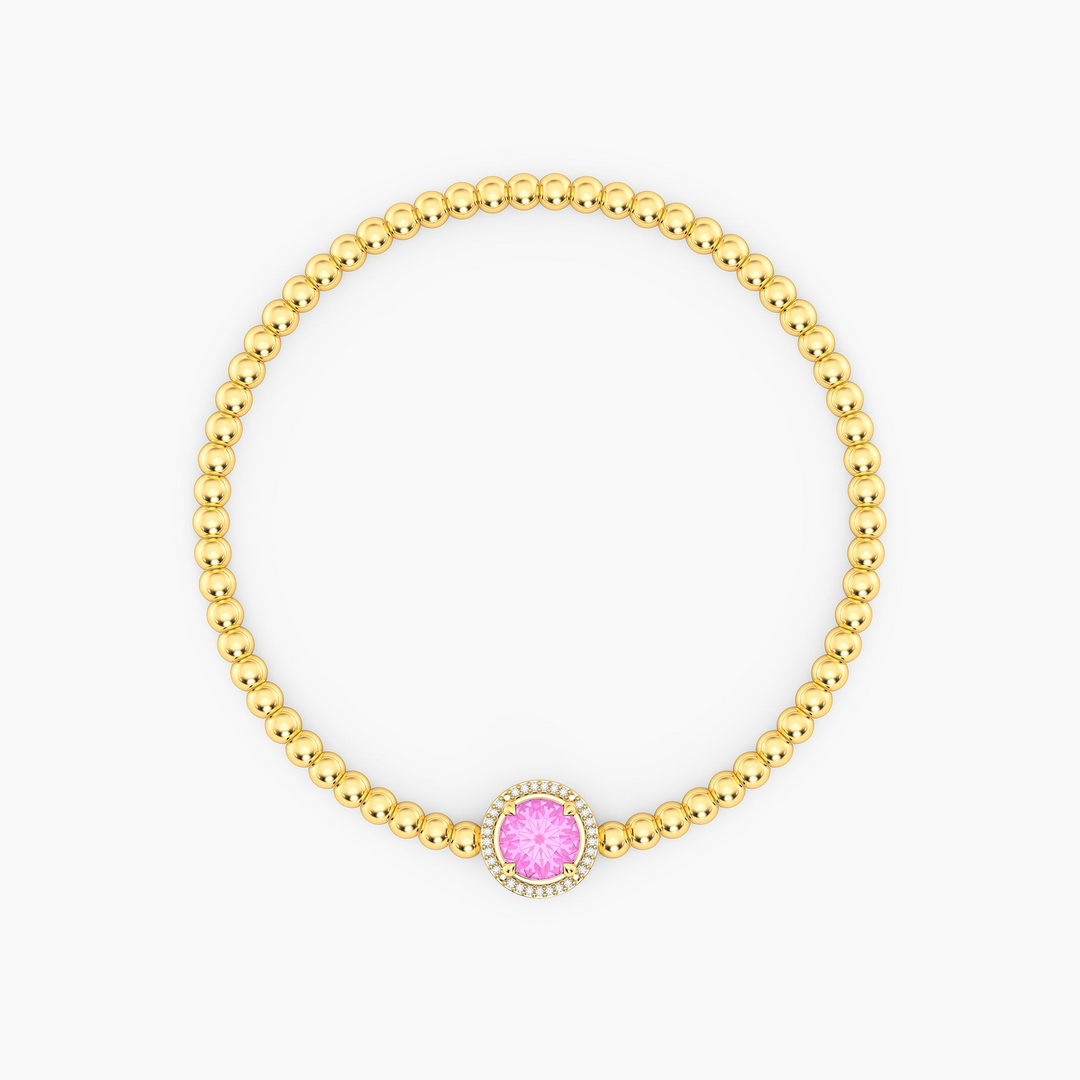 Gold plated beaded bracelet with a round pink center stone and diamond halo.