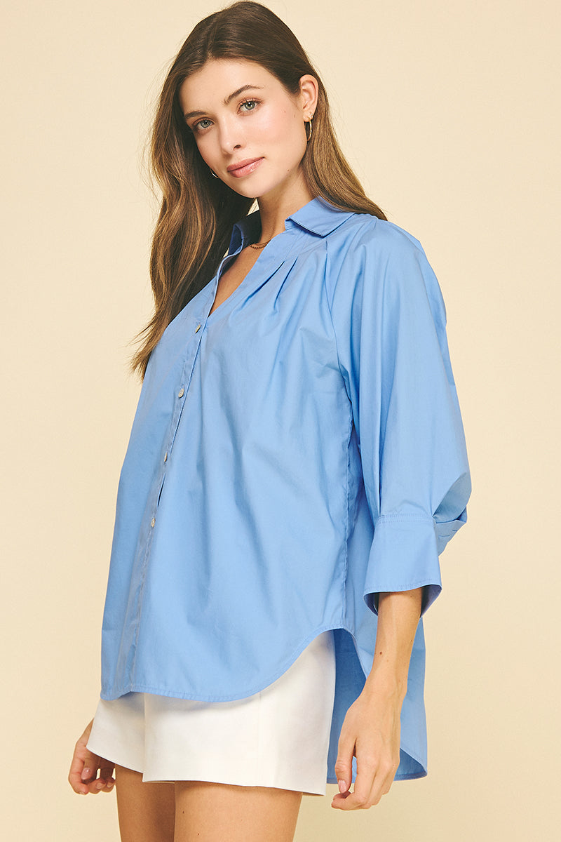 Women's white V-neck button-down shirt with wide cuffs, side slits, and a hi-lo hem in 100% cotton.