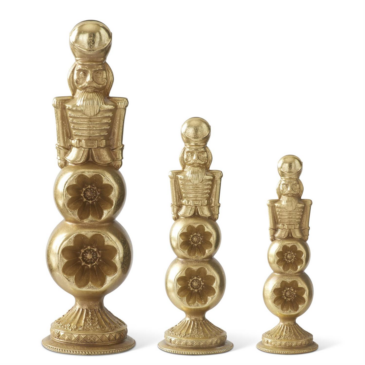 Three gold nutcracker figures in graduated sizes perched on tiered ornament finial bases.