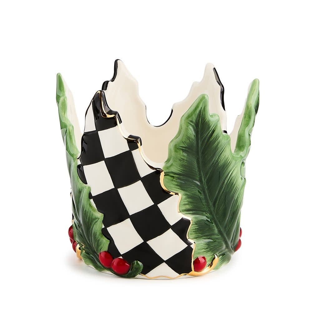 Short ceramic pillar candle holder with green holly leaf relief pattern on a white tray.