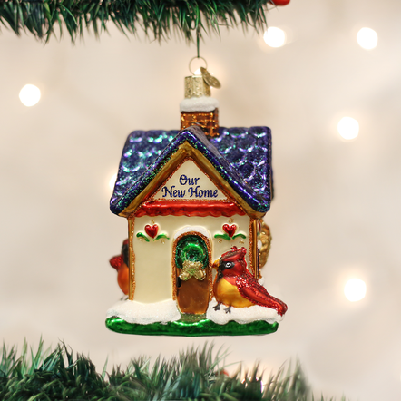 Mouth-blown glass cottage ornament with silver accents, hand-painted finish, and glitter details.