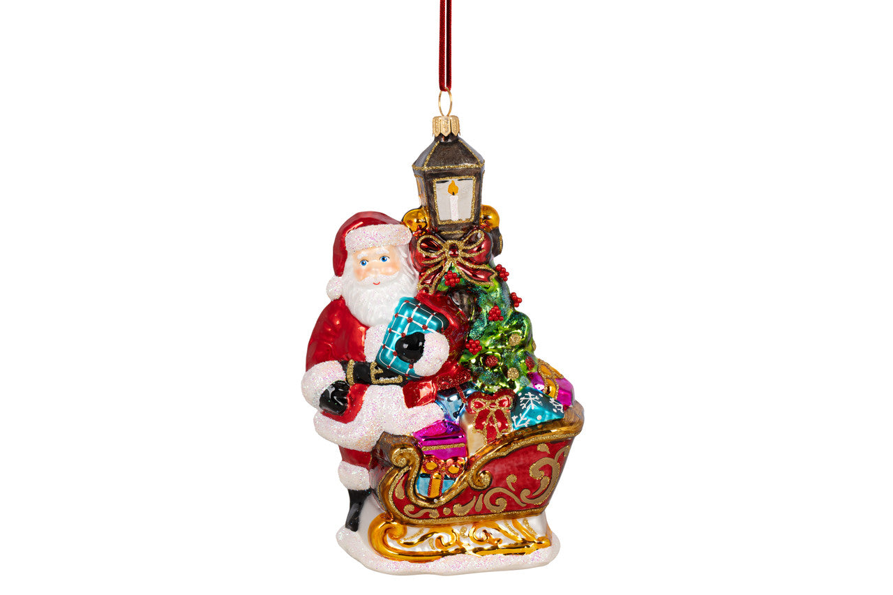 Hand-painted Santa with sleigh ornament featuring glitter finish in red and gold tones