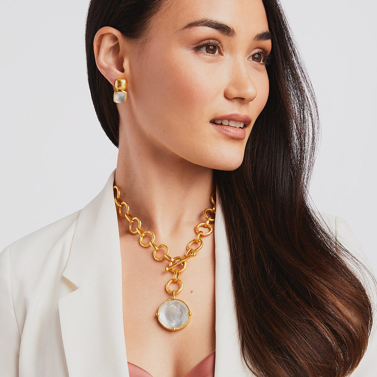 Gold statement necklace with hammered links featuring a round precision-cut gemstone pendant embellished with an engraved bee cameo.