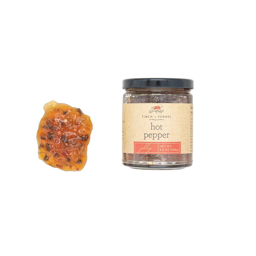 Glass jar containing red hot pepper jelly with a white lid