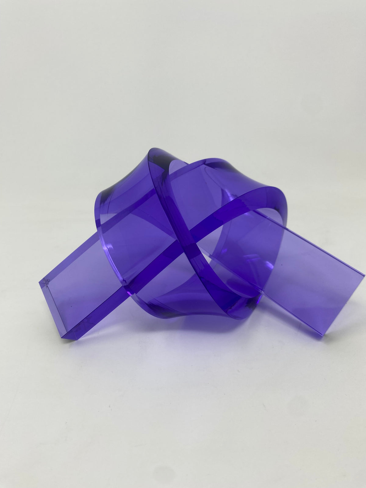 Acrylic knot pendant in clear acrylic with a black cord chain.