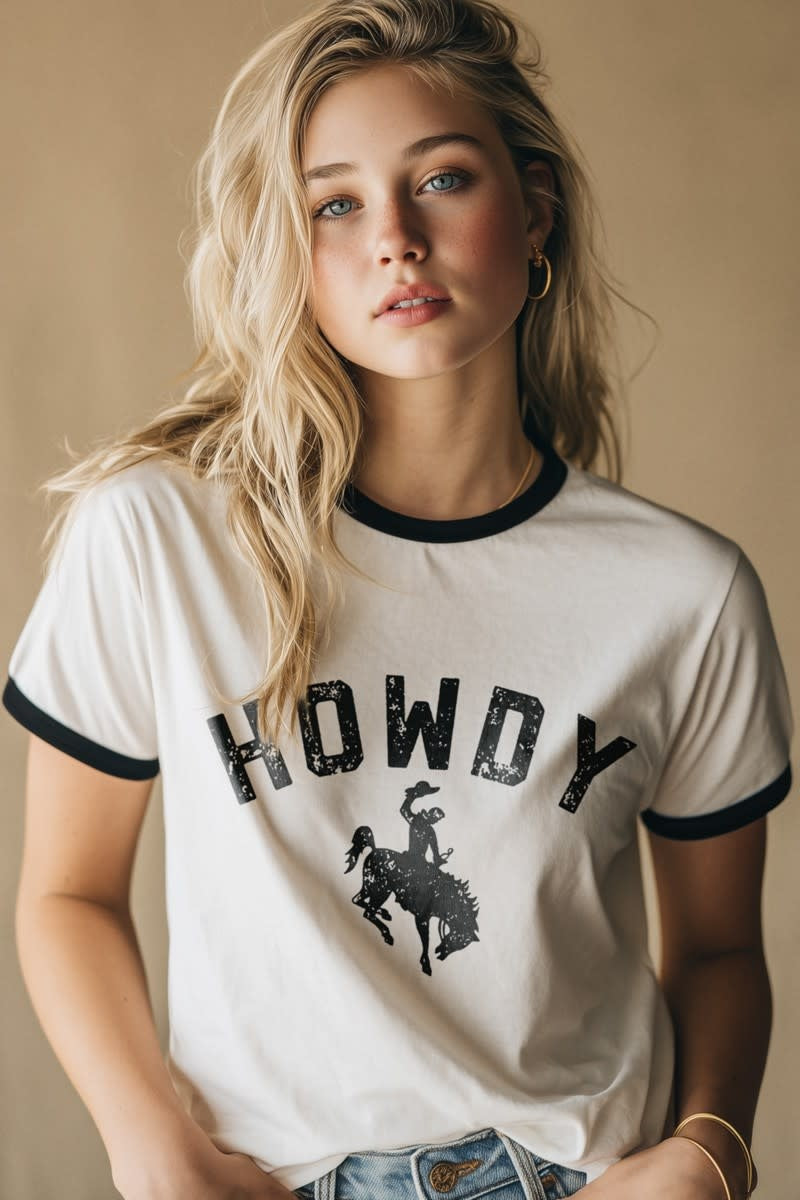 Relaxed fit western graphic tee with black trim, distressed HOWDY text, and bronco rider silhouette on USA cotton.