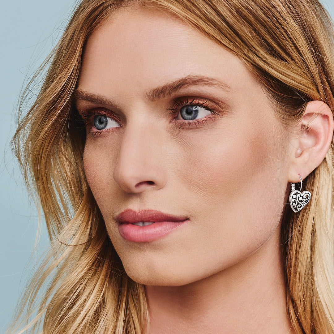Silver plated French wire leverback earrings with a heart-shaped drop measuring five-eighths inch wide.