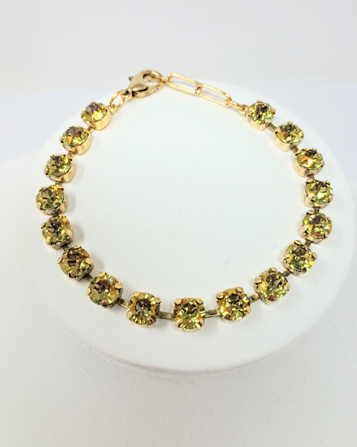 Sarina Bracelet featuring antique gold plating and round, sparkling olive green crystals.