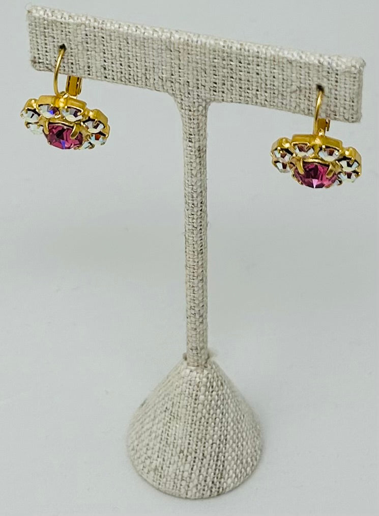 Gold round stud earrings featuring a pave-set stone center.