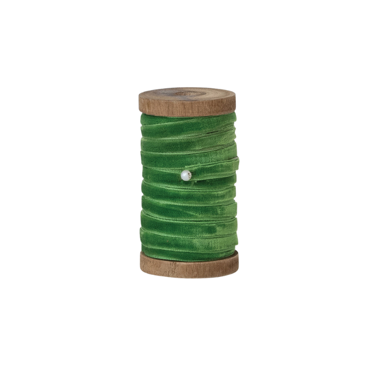 10 yards of 1/4 inch wide green velvet ribbon wrapped around a vintage-style wooden spool.