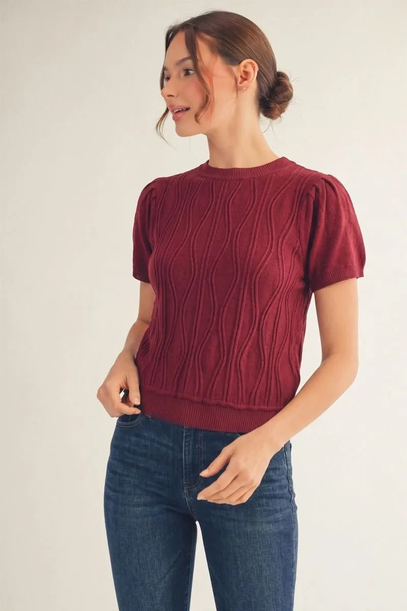 Woman wearing the Miranda burgundy short sleeve lightweight sweater with a wave knit pattern.