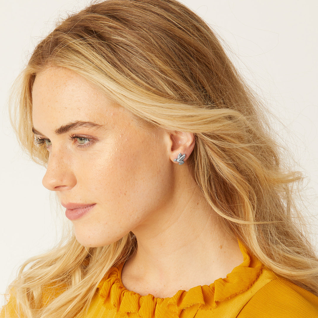 Silver plated mini post earrings featuring a hummingbird silhouette with detailed wings.