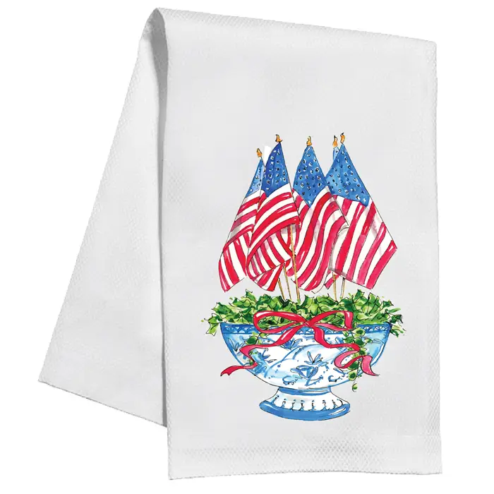 White cotton kitchen towel with watercolor American flags in a blue and white bowl with a red bow.