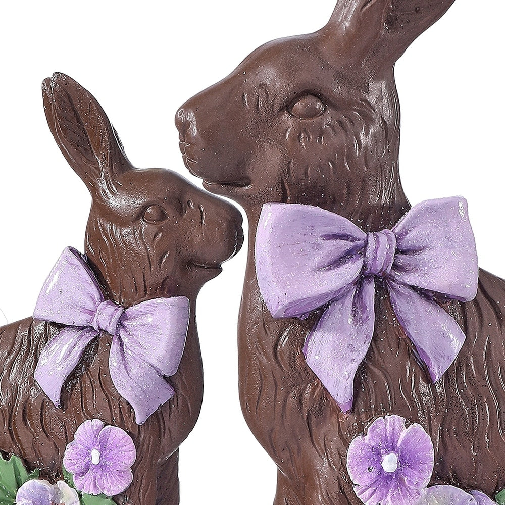 Resin chocolate bunny figurine with a delicate pansy flower accent on its ear.