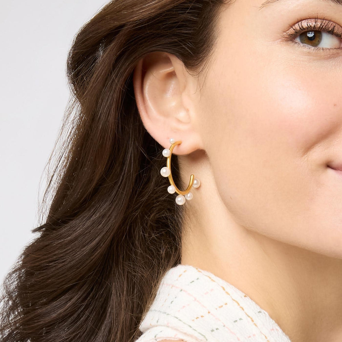 Slender 24K gold hoop earrings studded with varying sizes of gumdrop-like gemstones.