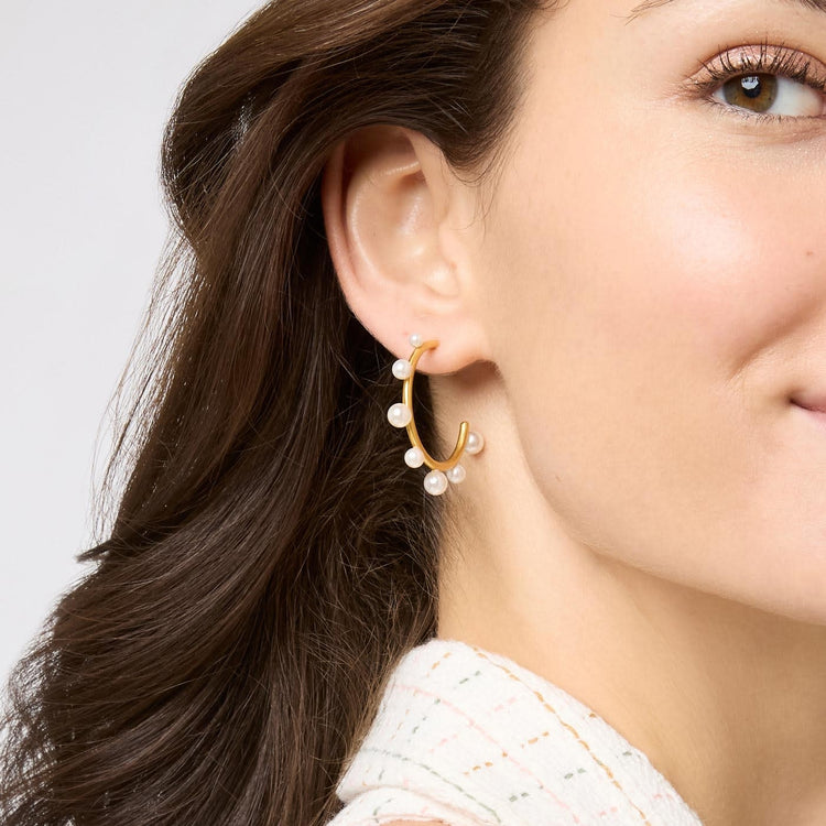 Slender 24K gold hoop earrings studded with varying sizes of gumdrop-like gemstones.