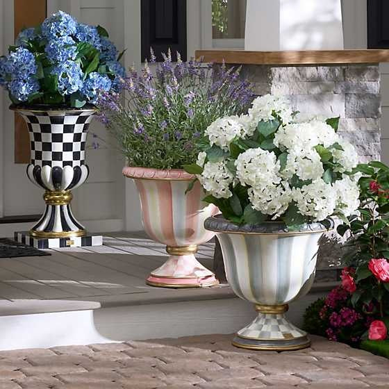 Black plastic pot containing artificial hydrangea flowers in a full round shape.