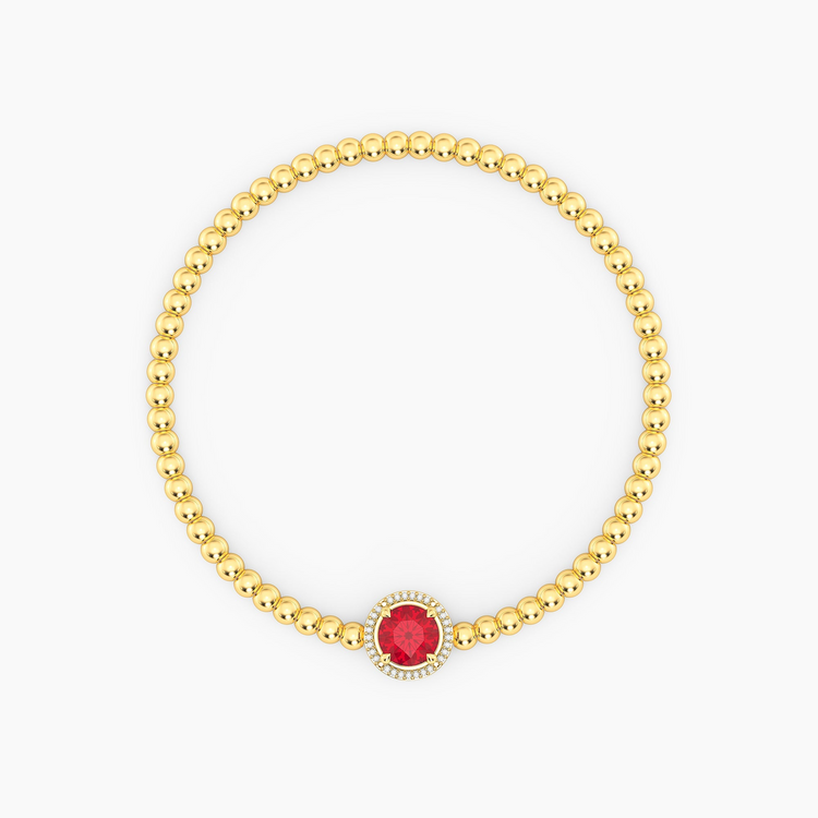 Gold beaded bracelet with a round red center gemstone and a halo of small diamonds.