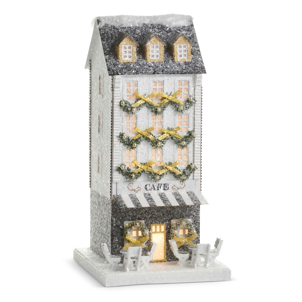 14.5-inch lighted paper cafe building with glittery snow, gold garlands, and outdoor seating.