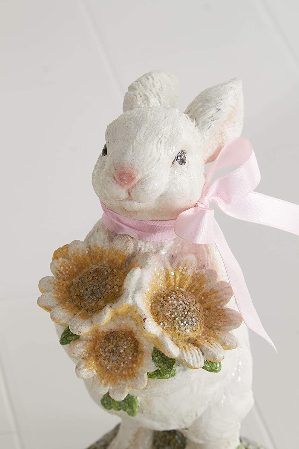 Polyresine glitter bunny figurine with pink bow holding flowers