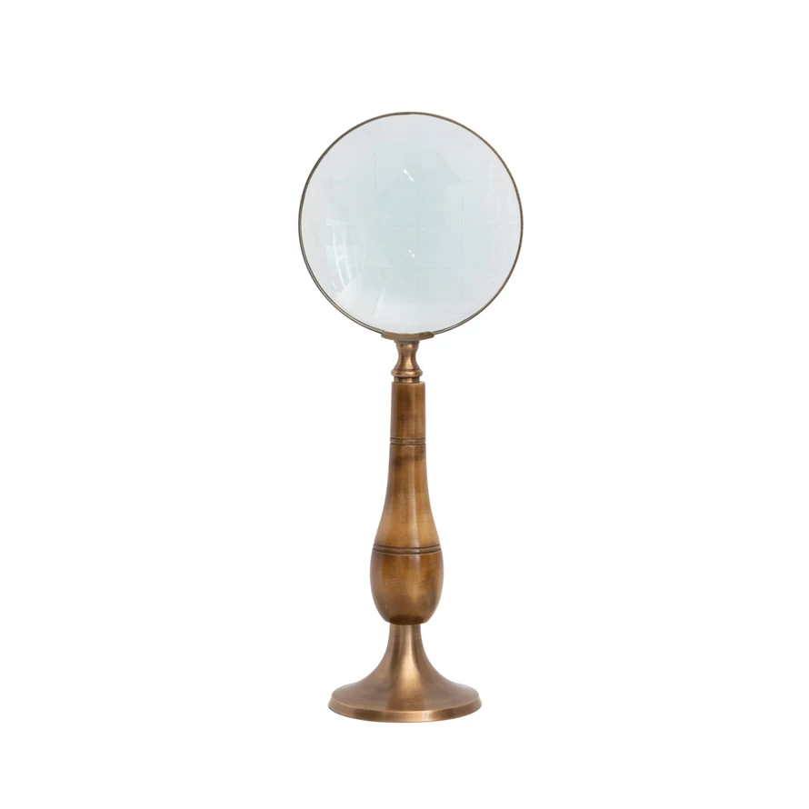 Antique brass magnifying glass on a bone stand with wooden base