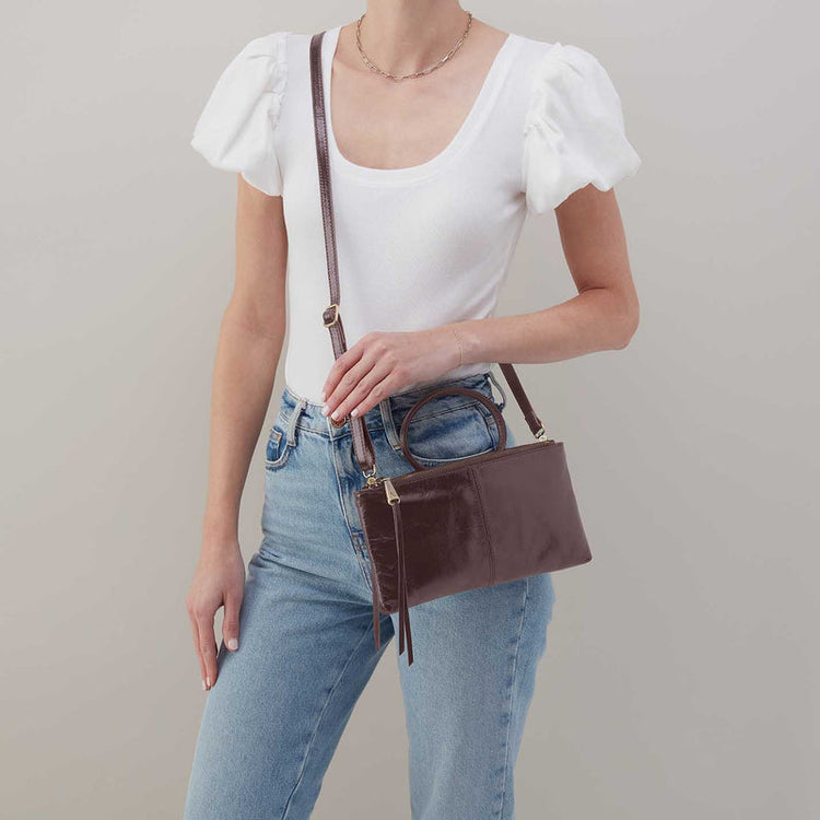 A person wearing a white puff-sleeve top and jeans, carrying the Sable Crossbody in Hearthstone.