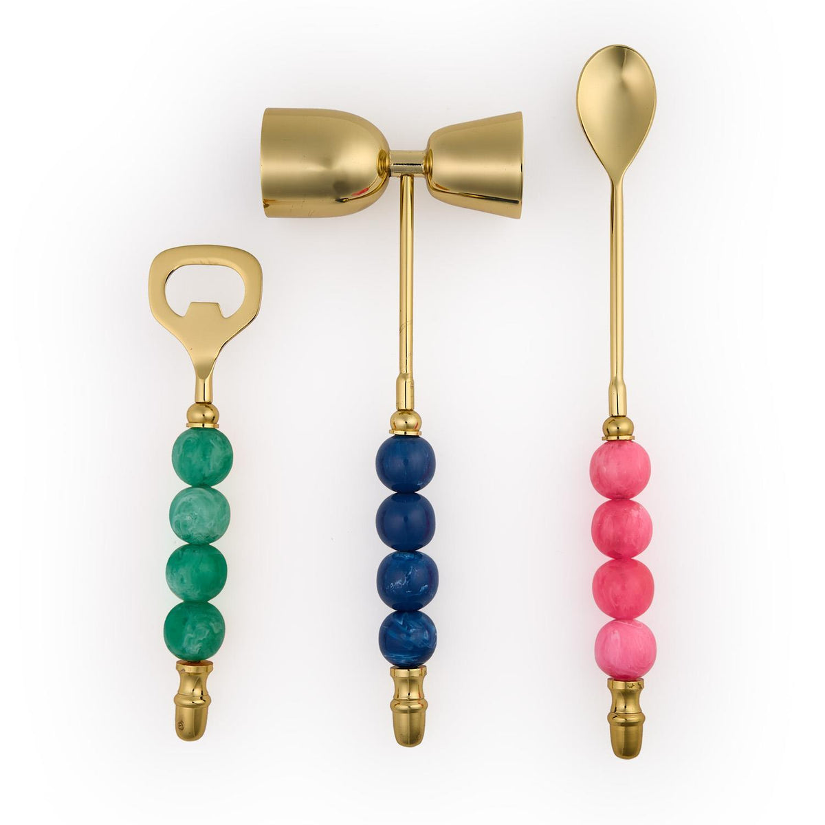 Gold bar set with a green bottle opener, blue jigger, and pink mixing spoon with beaded handles.