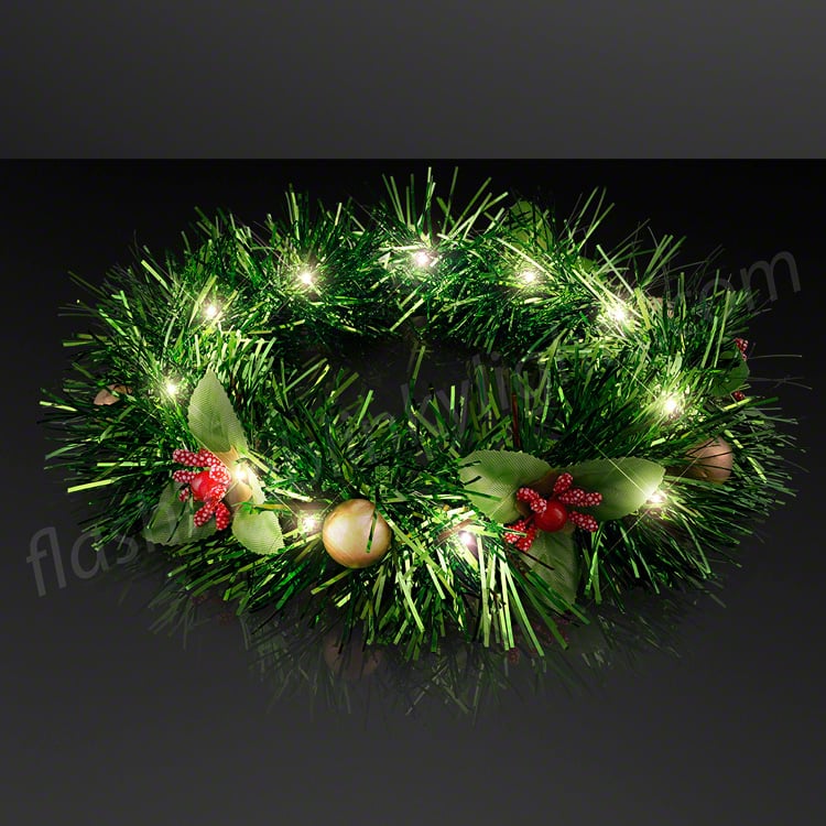 Green tinsel Christmas wreath headband with warm white LED lights, red berries, and gold ornaments.
