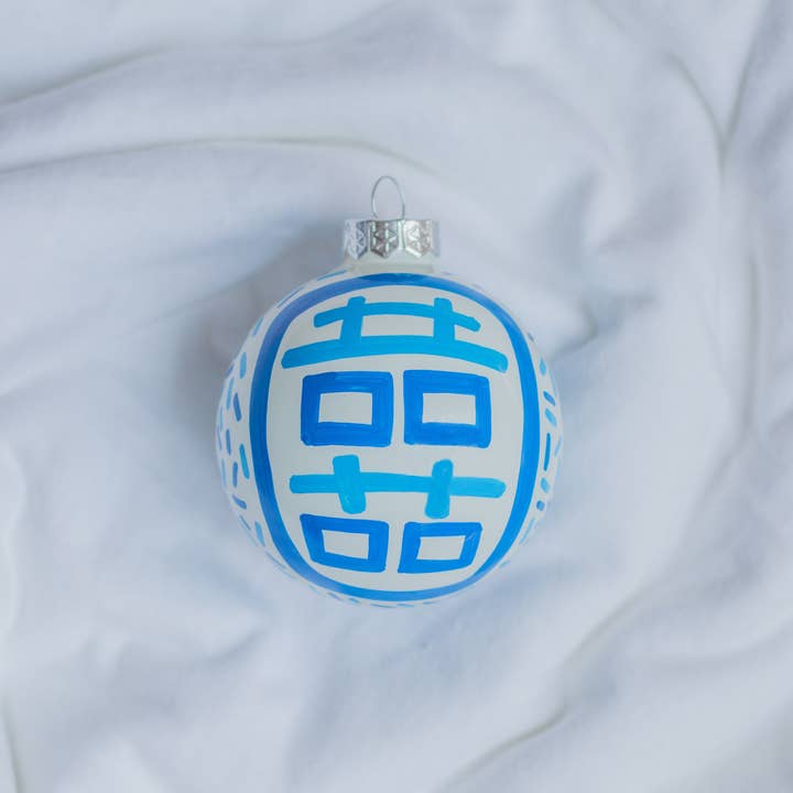 Hand-painted ceramic ornament featuring a red double happiness symbol on a white background.