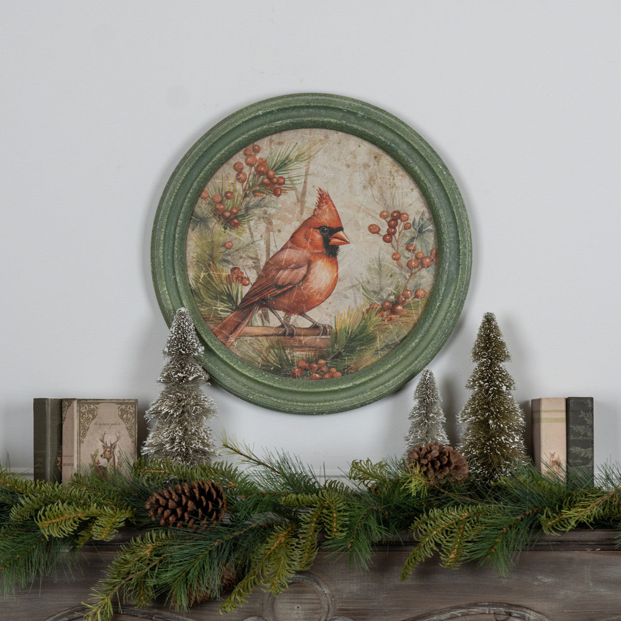 Round glass wall clock with a wooden frame featuring a holiday scene of red cardinals on branches.