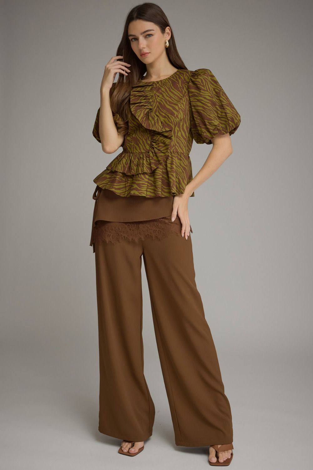Woman wearing a Serena animal print short puff sleeve top with ruffles and brown wide-leg pants.
