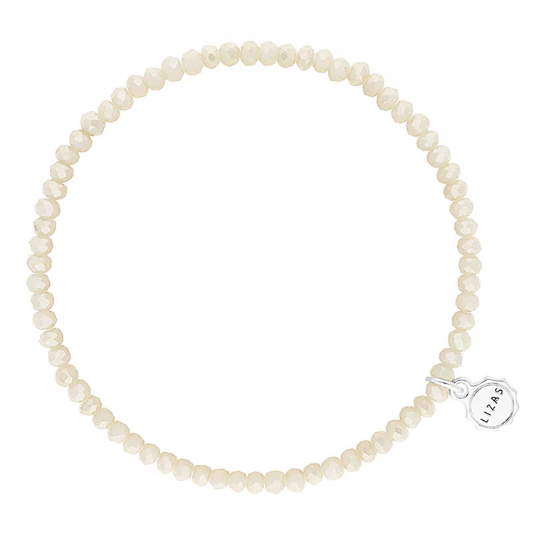 Lizas Quadro Big crystal stretch bracelet in cream with a silver logo charm.