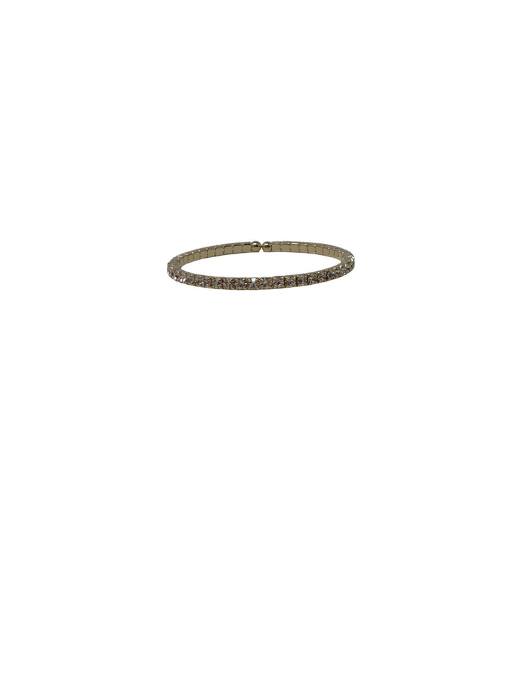 Single row crystal stretch cuff bracelet in a gold-tone setting against a white background.