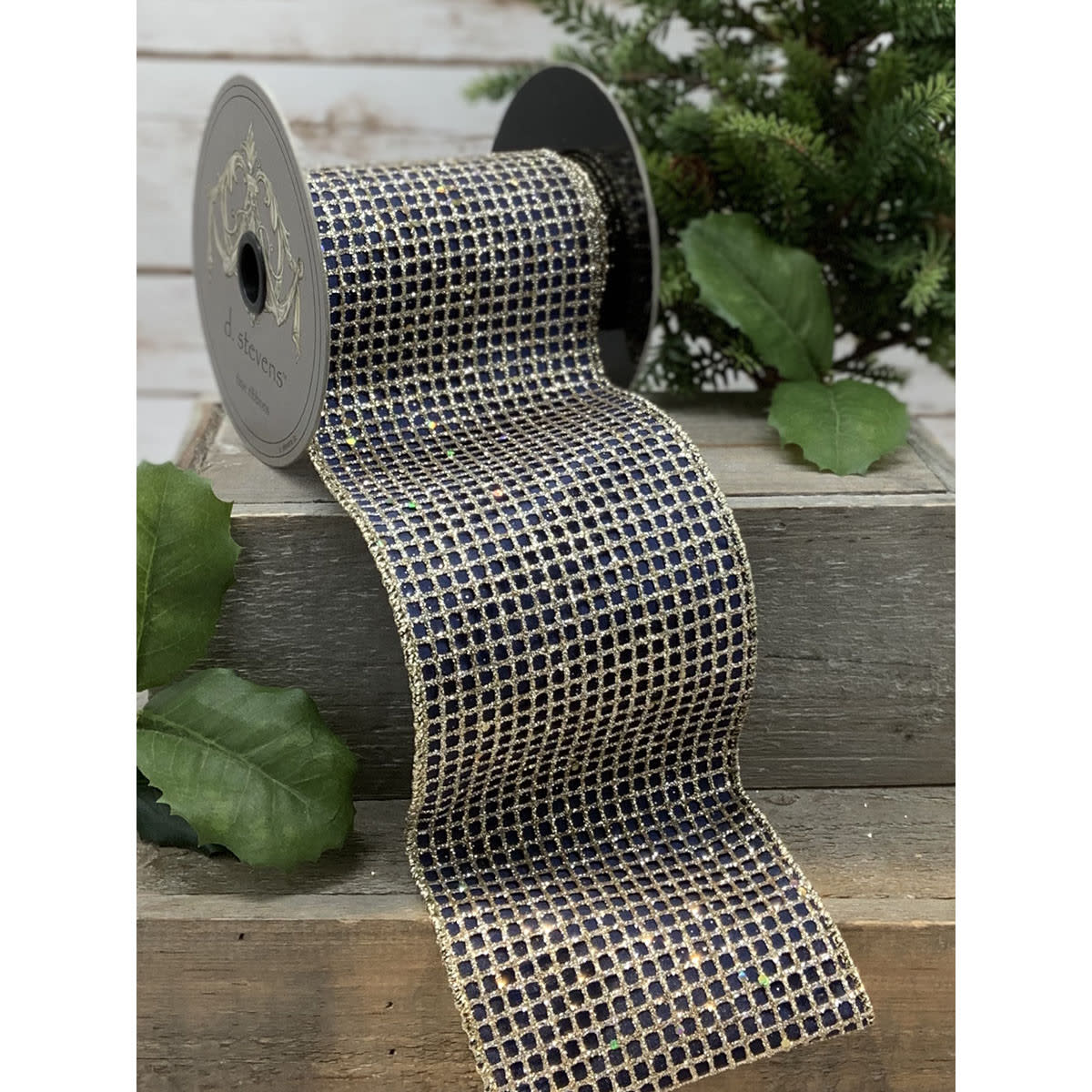 4 inch navy taffeta ribbon with a gold mesh overlay on a spool, displayed on wooden crates.