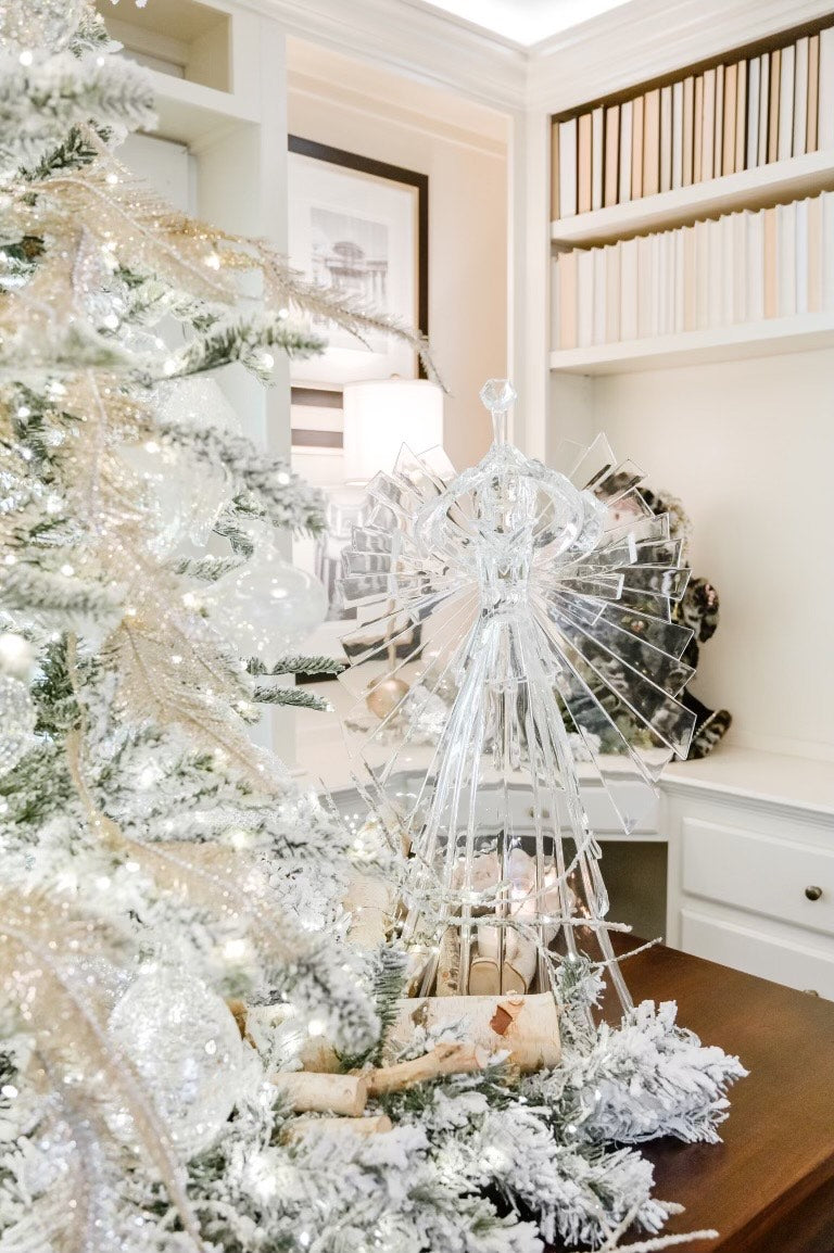Large 34-inch clear acrylic angel with detachable wings on a table next to a flocked Christmas tree.