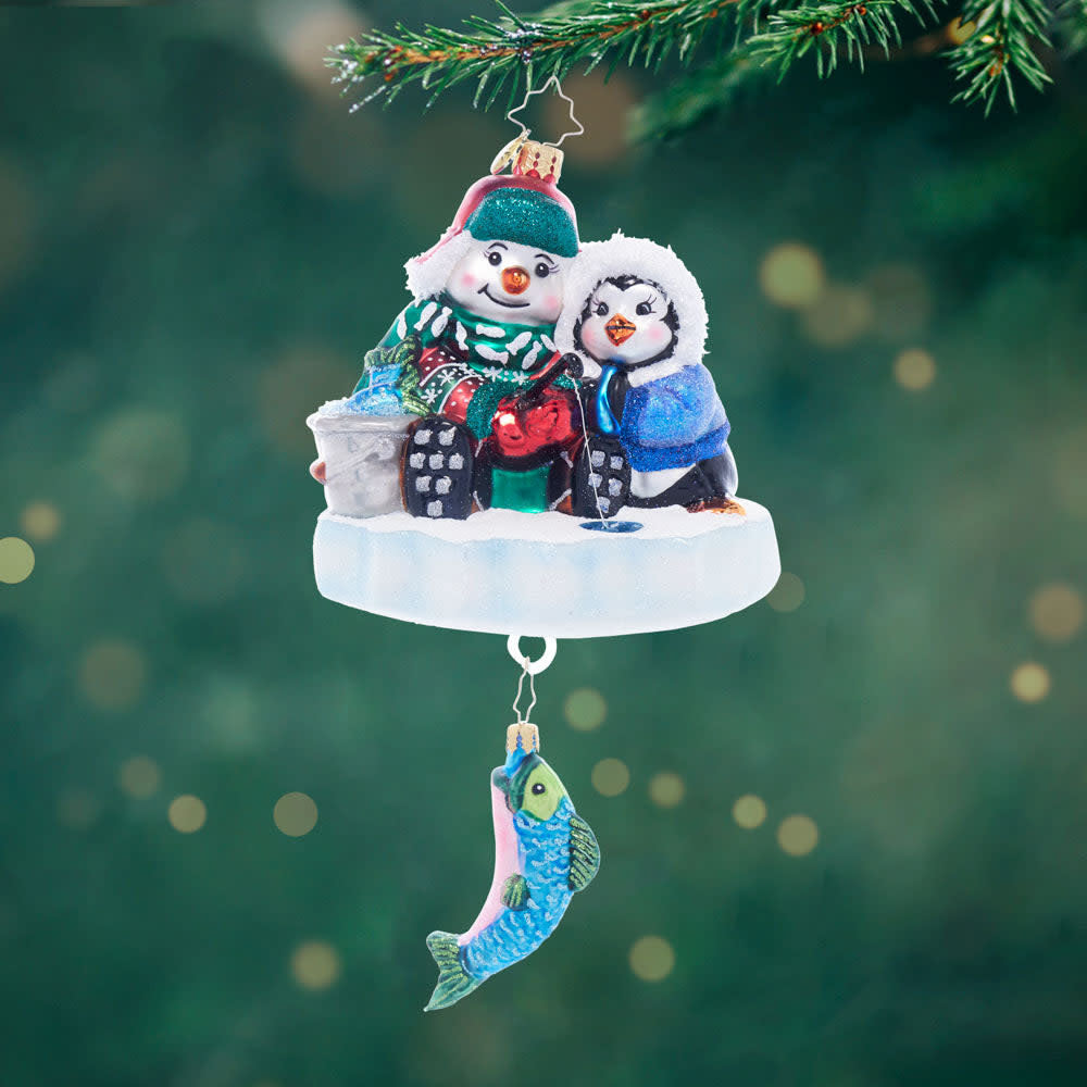 Front view of Ice Fishing Snow Pals figurine in blue plastic with fishing rod and snowflake details.