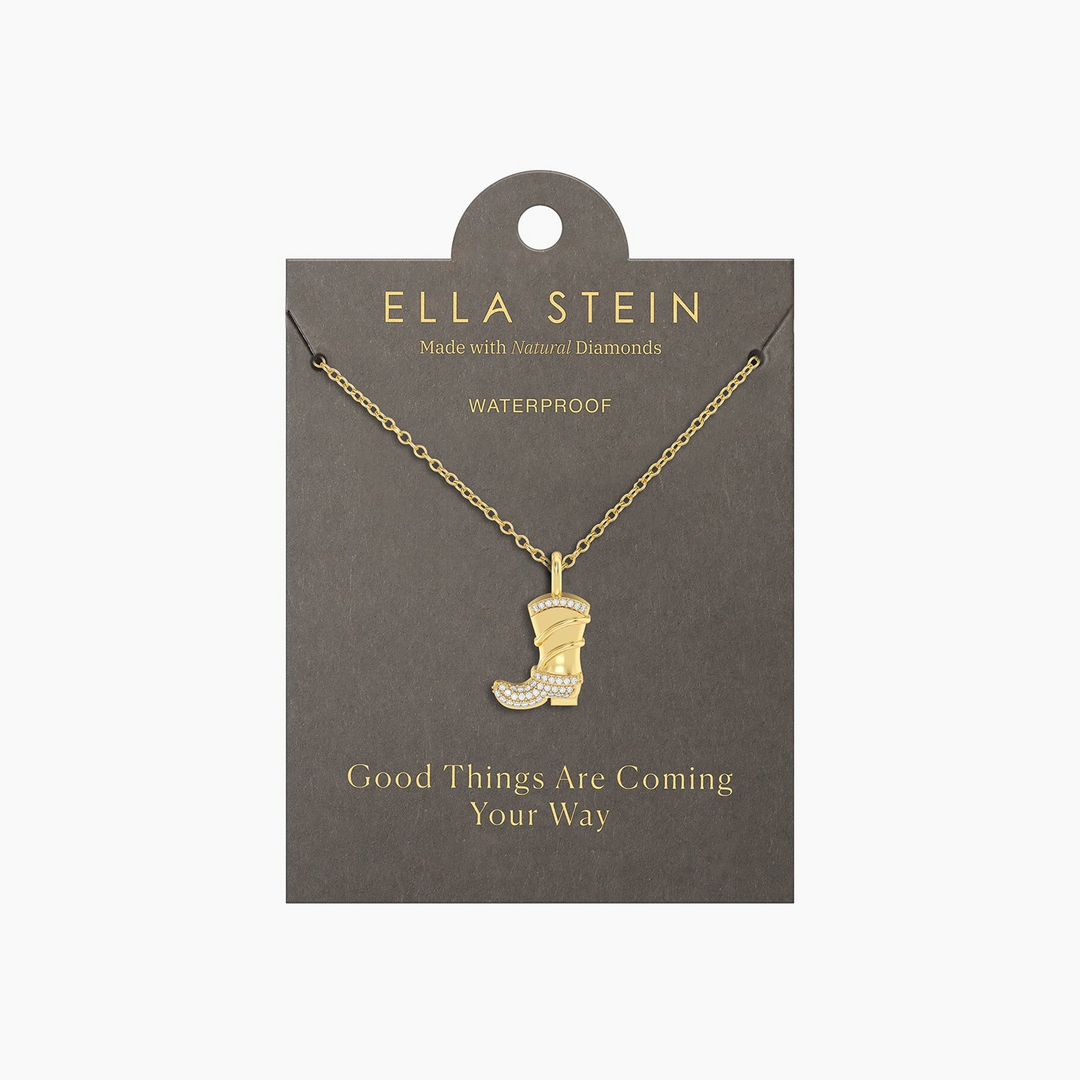 Gold cowgirl boot pendant necklace with diamond accents on a grey display card.