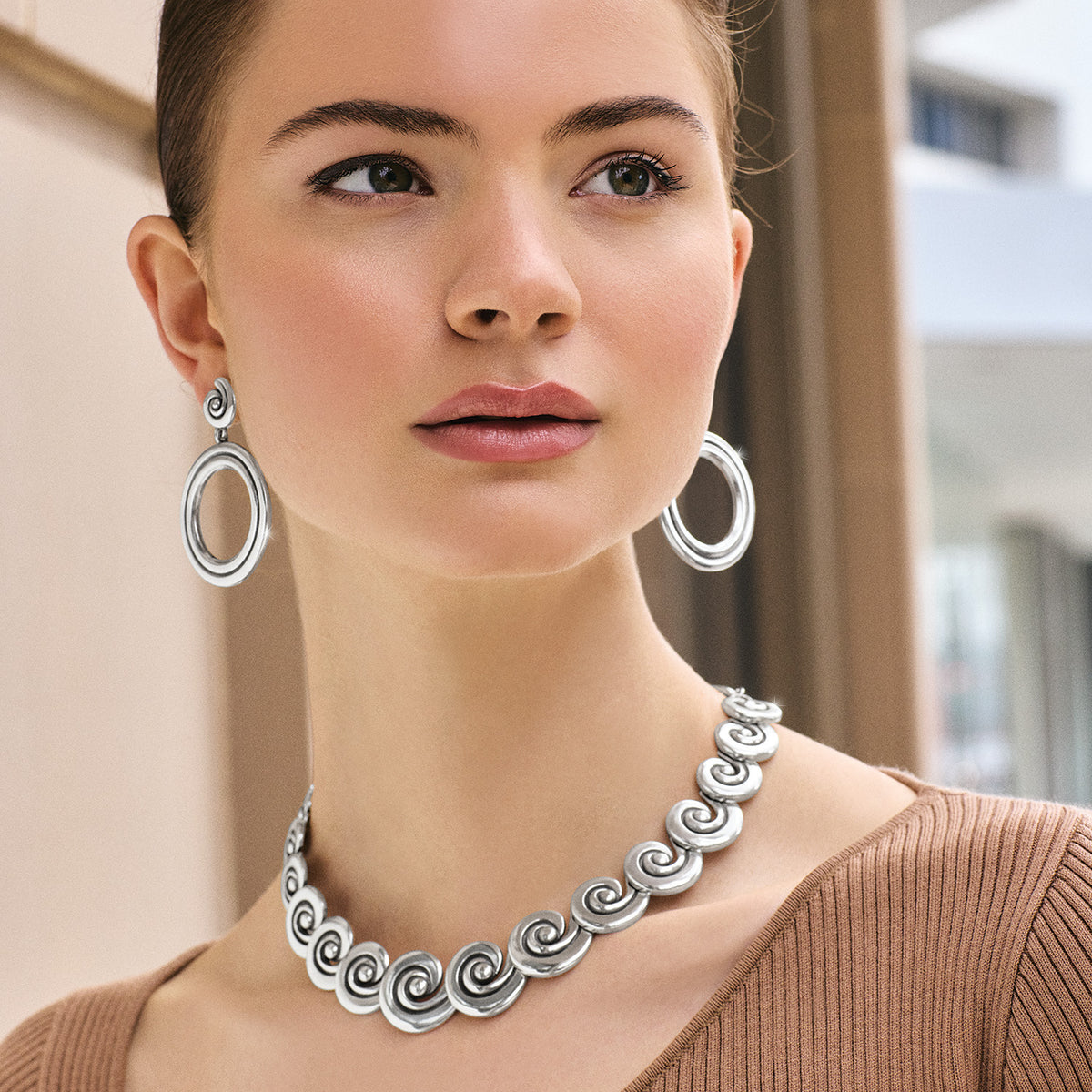 Silver plated Contempo Moda swirl necklace with lobster claw closure on an adjustable chain.