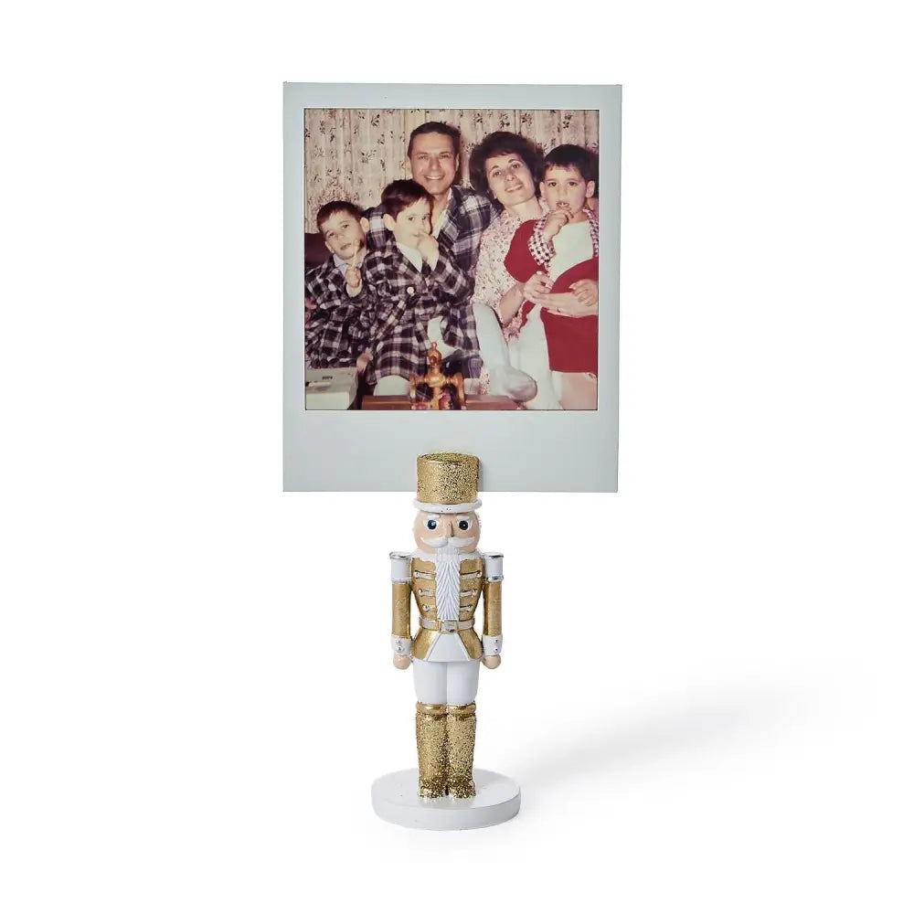 Gold and white glitter nutcracker place card holder displaying a family photo.