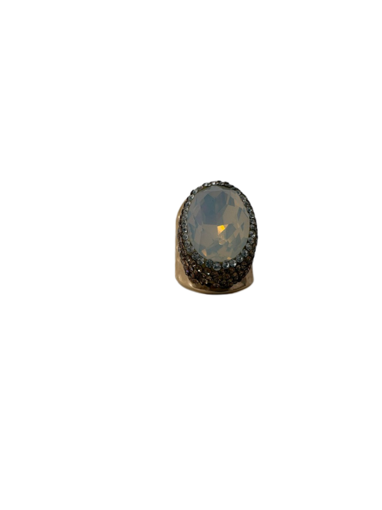 Fashion gemstone ring featuring a large oval faceted white stone surrounded by small crystals.