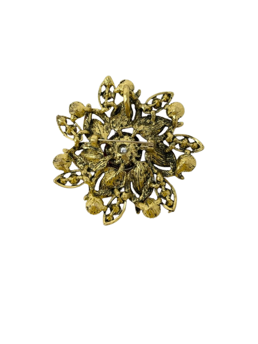 Back view of a gold-toned flower brooch with a pin fastener and textured metal finish.