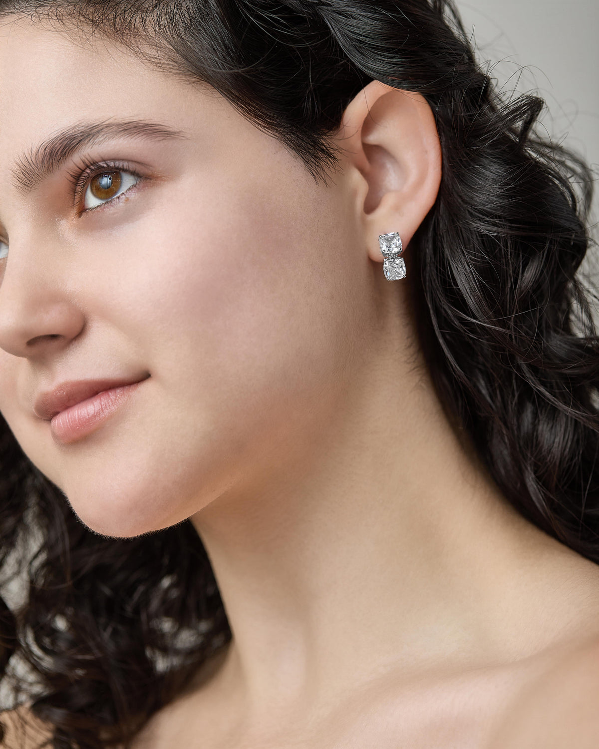 Model wearing Clair Double Drop Earrings featuring two stacked square-cut cubic zirconia stones.