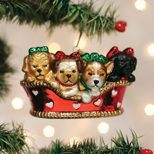 Glass Christmas ornament featuring four different puppies wearing bows inside a red basket.
