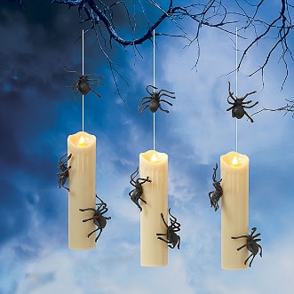 Three hanging LED candles with flickering lights and black spiders crawling on them and the strings.