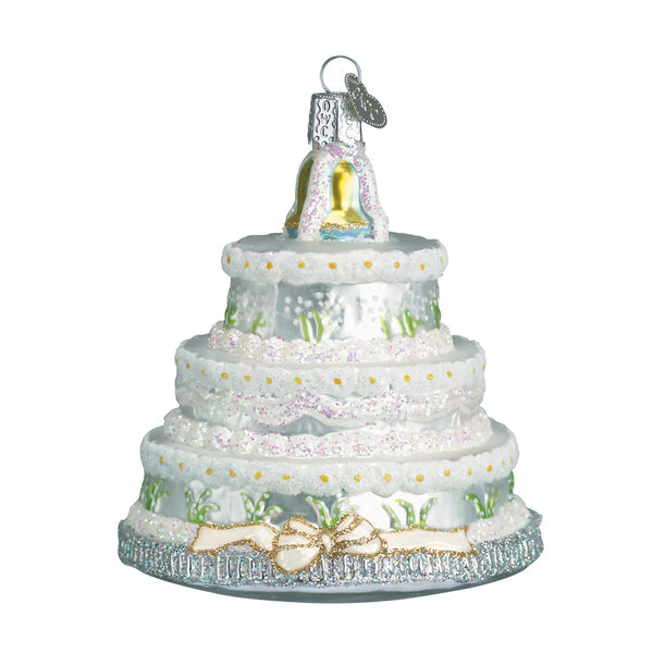 Three-tier white wedding cake Christmas ornament with glitter accents, floral details, and a bow.