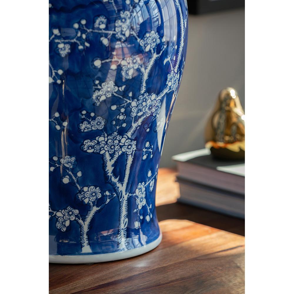 Small porcelain ginger jar with cherry blossom motif in pink floral pattern against white background.