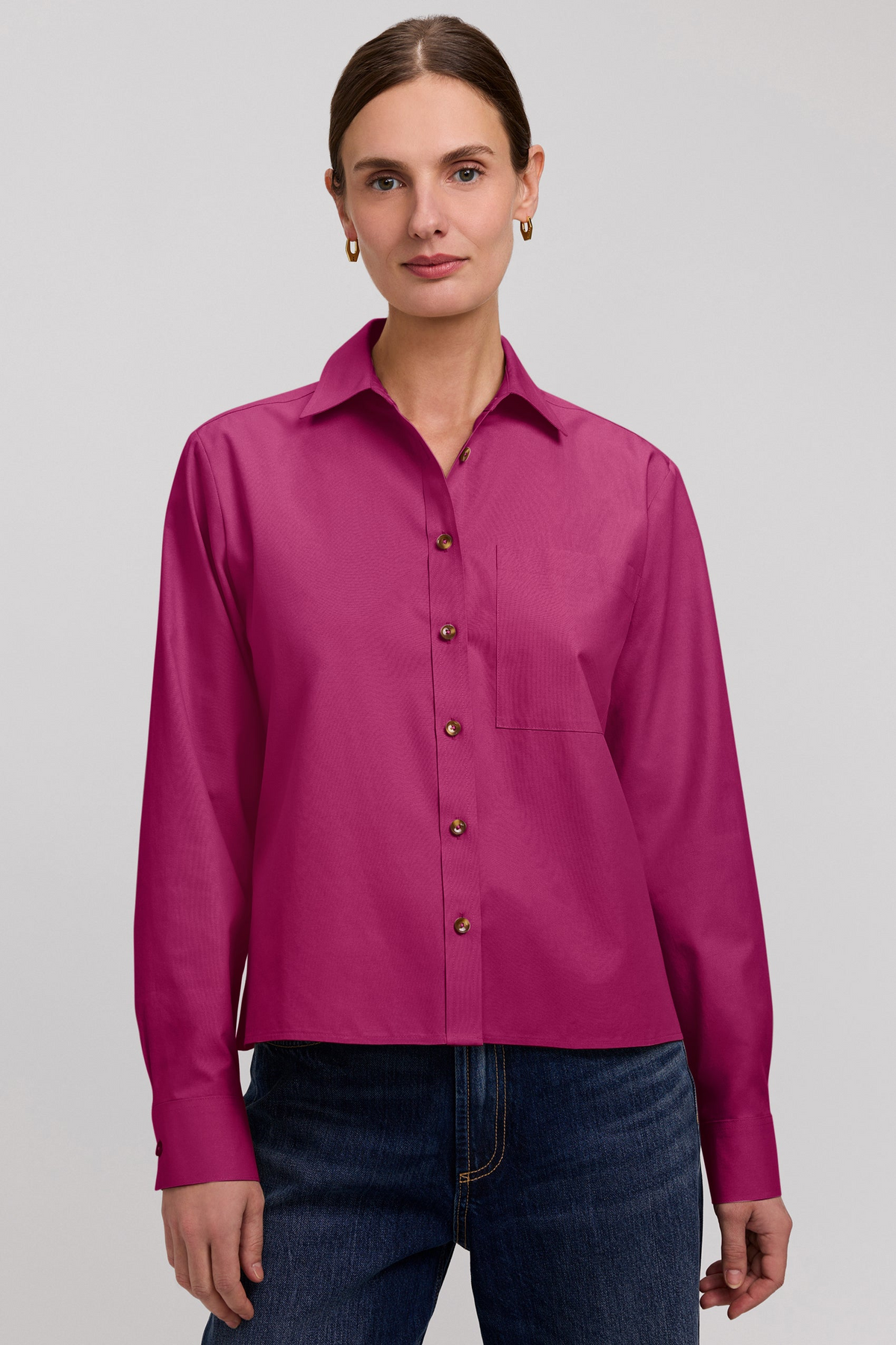 Woman wearing the Jodie No Iron Pinpoint Long Sleeve Short Shirt in magenta with dark blue jeans.