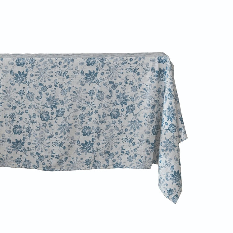 White cotton slub tablecloth with a blue floral print draped over a table corner.